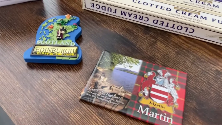 Image Shows a Collection of Scottish Souvenirs Including a Blue Magnet with "Scotland Edinburgh" Text, a Book Titled "Loch Lomond, Highlands," and Boxes of Clotted Cream Fudge