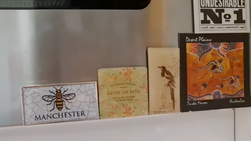 Image Displays a Collection of Decorative Magnets and Tiles Featuring Various Themes, Including a Manchester Bee, French Quotes, and Aboriginal Art from Australia