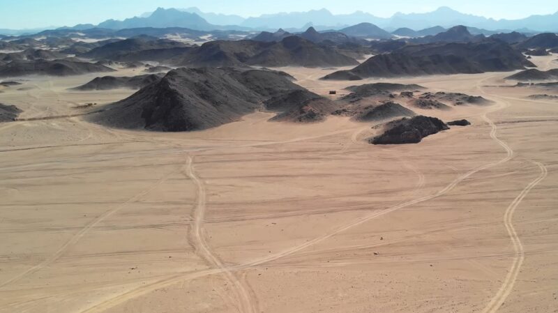 African desert landscape in the Sahara with rocky hills and wide sandy plains